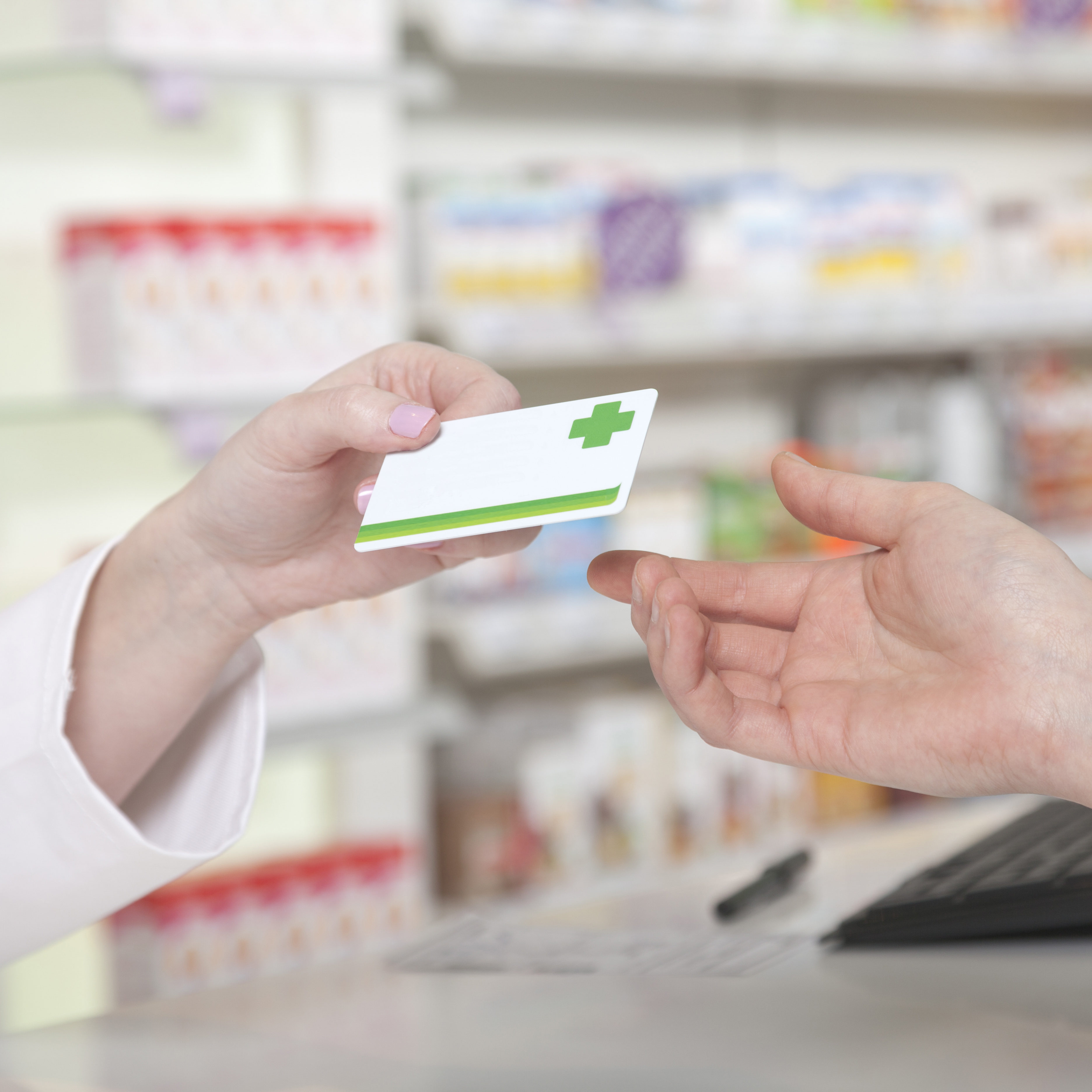Card payment in pharmacy Customer hands over her payment customer card in pharmacy drugstore shop environment